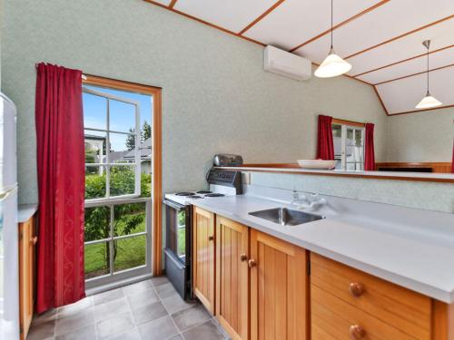 陶波Wonderful 2BR Cottage Nr Huka Falls w Aircons的一个带水槽和大窗户的厨房