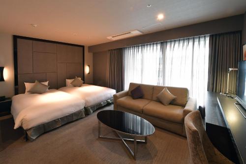 名古屋名古屋可信白河酒店的酒店客房,配有床和沙发