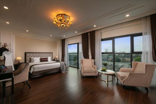 河内Adonis Hotel的一间卧室配有一张床、两把椅子和一个吊灯