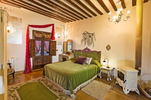 托莱多Casa Palacio Rincón de la Catedral的一间卧室配有一张带绿床罩的床