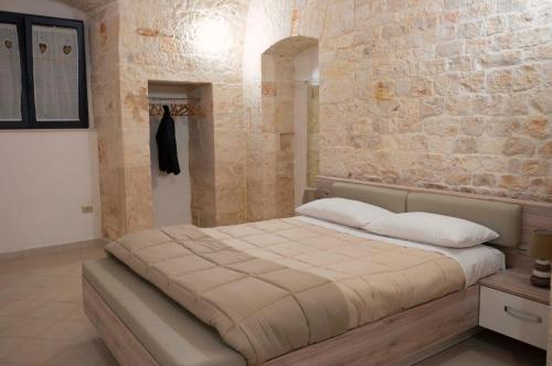 图里Pietranuova的一间卧室设有一张带石墙的大床