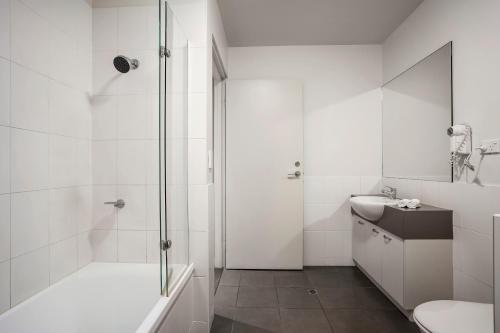 艾利斯斯普林斯Quest Alice Springs的带淋浴和盥洗盆的白色浴室