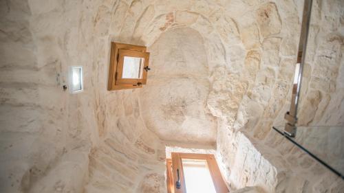 阿尔贝罗贝洛阿斯特拉酒店的浴室设有石墙和窗户