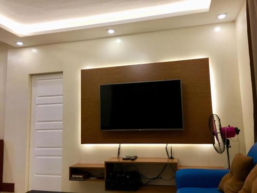 宿务Arcadio's Guest House in Mactan, Cebu的客厅的墙上配有电视