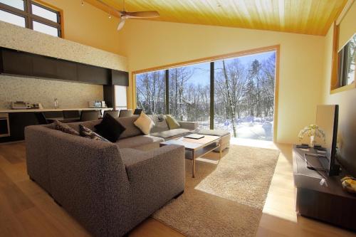 白马村Solar Chalets by Hakuba Hospitality Group的客厅配有沙发和桌子