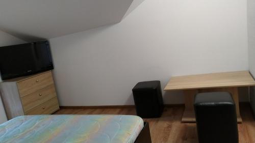哈斯科沃Самостоятелен етаж от къща за гости的一间卧室配有一张床、一张书桌和一台电视。