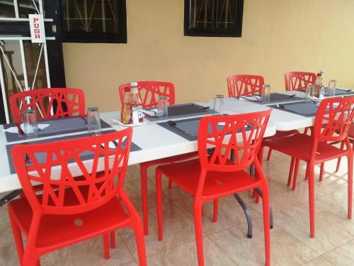 GuluDich Comfort Hotel - Main Branch的一张桌子、红色的椅子和白色的桌子
