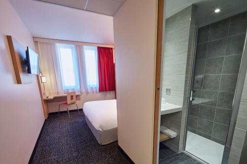 克莱蒙费朗Premiere Classe Clermont Ferrand Centre的酒店客房配有一张床和淋浴
