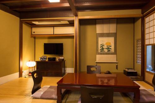 金泽金泽菊乃雅町屋的客厅配有桌子和电视