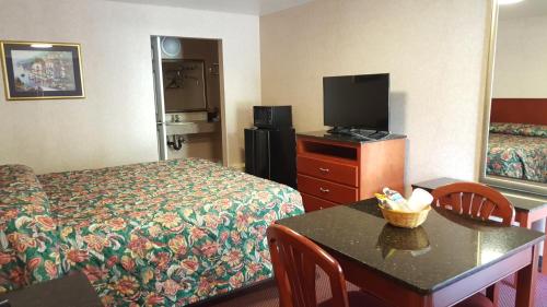 加洛韦中庭套房酒店的一间酒店客房,配有一张床、一台电视和一张桌子