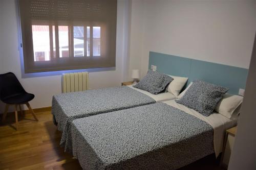艾利亚德亚罗萨Piso ILLA DE AROUSA, RISON的一间卧室设有两张床和窗户。