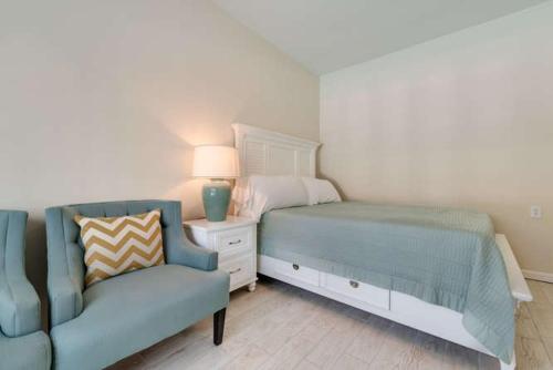 西耶斯塔岛Whitewood的一间卧室配有一张床、一张沙发和一把椅子