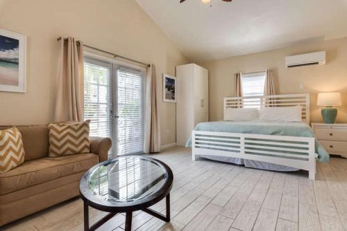 西耶斯塔岛Wild Plum的一间卧室配有一张床、一张沙发和一张玻璃桌