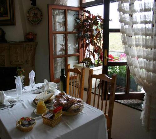 Borleña德柏丽娜酒店的窗户房间里一张带食物的白色桌子