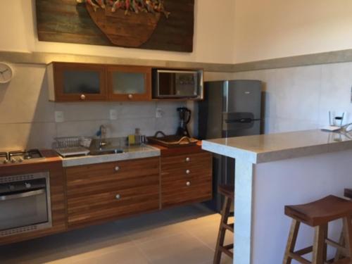 普拉亚多Praia do Forte Apartamento Fantástico的厨房配有水槽、炉灶和冰箱