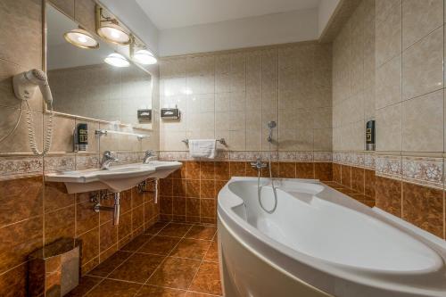 普雷绍夫卡普迪姆精品酒店的浴室设有2个水槽、浴缸和镜子
