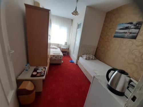 SeyhanSAYDAM OTEL的小房间,配有床和红地毯