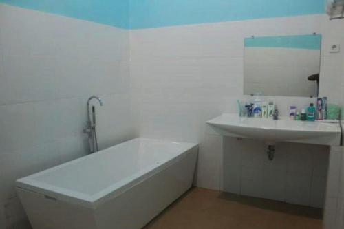 英德GLOBAL VIEW HOTEL的白色的浴室设有浴缸和水槽。