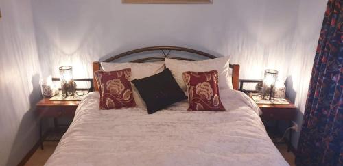 约克York's Lookout Lodge Bed And Breakfast的一间卧室配有一张带枕头的床和两盏灯。