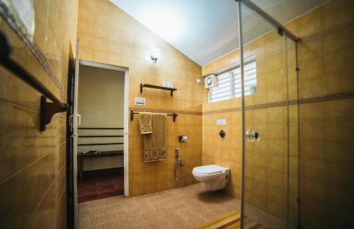 迈索尔Gitanjali Homestay的一间带卫生间和玻璃淋浴间的浴室