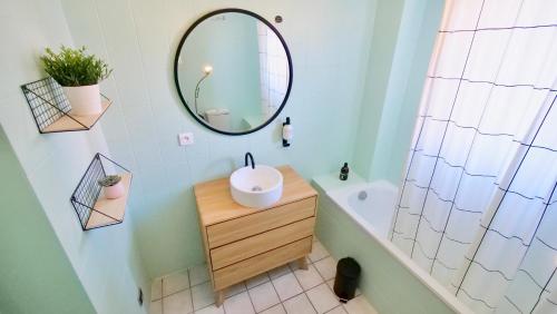 希尔蒂盖姆Bonheur的浴室设有镜子、水槽和浴缸