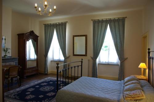 Léran拉帕瑟杜坦普勒住宿加早餐旅馆的一间卧室设有一张床和两个窗户。