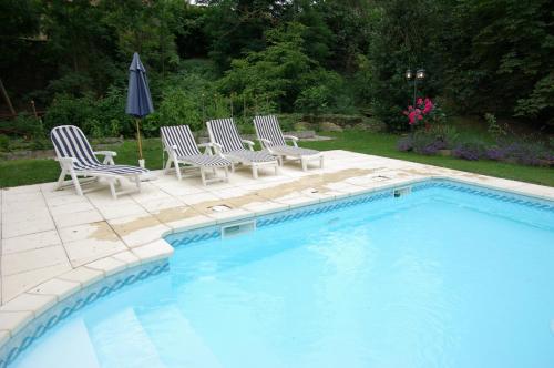Léran拉帕瑟杜坦普勒住宿加早餐旅馆的游泳池旁配有椅子和遮阳伞
