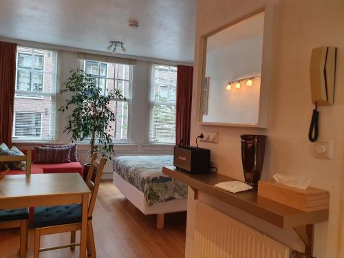 阿姆斯特丹Huis Roomolen的酒店客房配有一张床铺、一张桌子和一张书桌。