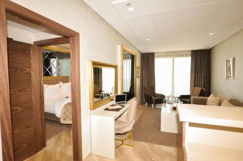 卡萨布兰卡Suite Hotel Casa Diamond的配有一张床和一张书桌的酒店客房