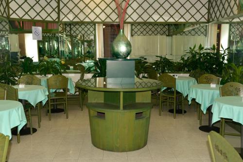 都灵阿玛迪斯缇亚特洛酒店的中间设有1间带桌椅和花瓶的餐厅