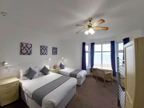 桑当Marina的一间卧室配有两张床和吊扇