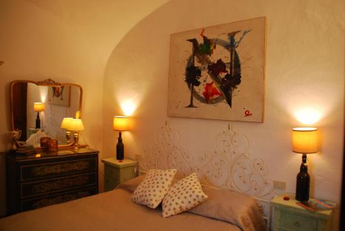 圣吉米纳诺Orto di Emma的一间卧室配有一张带两盏灯和镜子的床