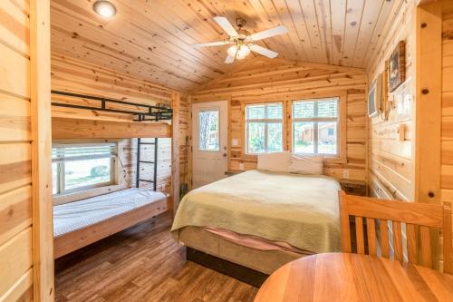 韦尔奇蒙特胡德村5号豪华度假屋的小木屋卧室配有床和吊扇