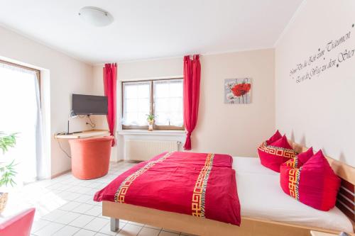 GransdorfGasthaus zum Holzwurm的一间卧室配有一张带红色枕头的大床