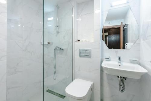 奥赫里德佩拉酒店的带淋浴、卫生间和盥洗盆的白色浴室