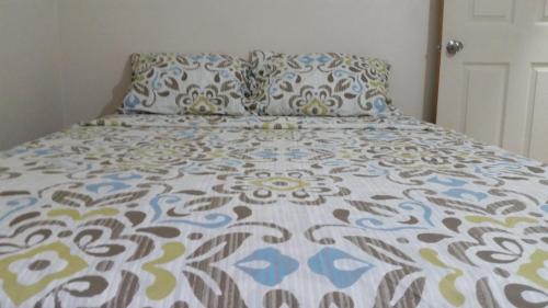 格罗斯岛East Caribbean Lodging的一张带色彩缤纷的被子和枕头的床