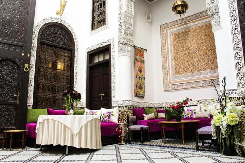 非斯Le Grand Alcazar - Riad的客厅配有紫色沙发和桌子
