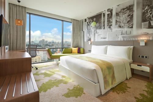 胡志明市Holiday Inn & Suites Saigon Airport, an IHG Hotel的一间卧室设有一张大床和一个大窗户