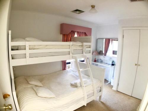 梅尔顿Melbourne Garden Bed and Breakfast的一间带两张双层床的卧室和一间浴室
