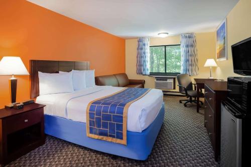 史蒂文斯波因特史蒂文斯波恩特斯戴旅馆及套房酒店的酒店客房设有一张大床和一张书桌。