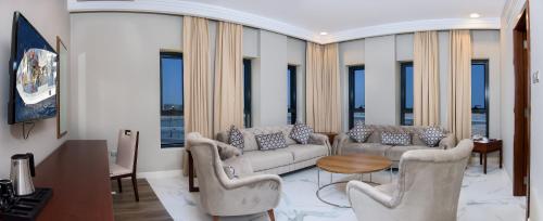 马斯喀特Muscat Gate Hotel的带沙发、桌子和窗户的客厅