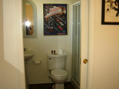 弗吉尼亚城弗吉尼亚城酒店的一间带卫生间的浴室和墙上的照片