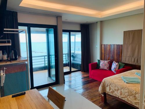 哈林海滩Petit Suncliff Resort的客房设有床、红色沙发和阳台。