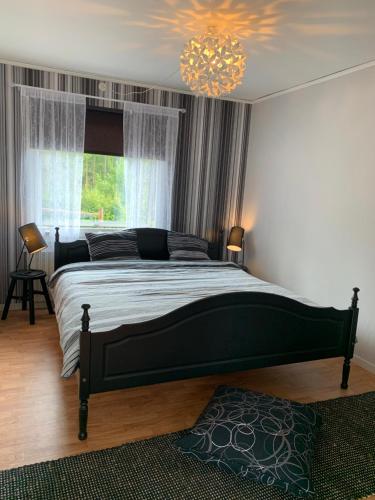 科斯塔Cozy house in Kosta center surrounding with Swedish nature的一间卧室配有一张大床和一个吊灯。