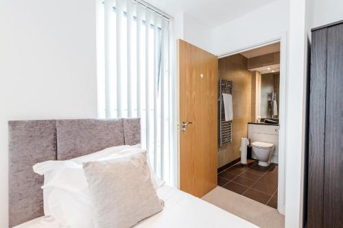 伦敦EXCEL LONDON MAJESTIC APARTMENT的一间卧室配有一张床,浴室设有卫生间