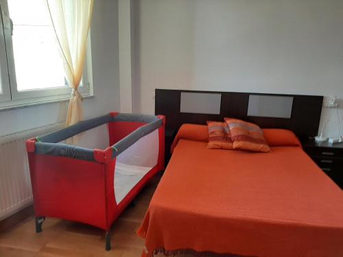 卢戈Precioso apartamento的一间卧室配有红色的床和椅子