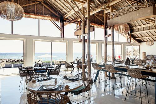 达赫拉La Crique Nature & Spa的用餐室设有桌椅和窗户。