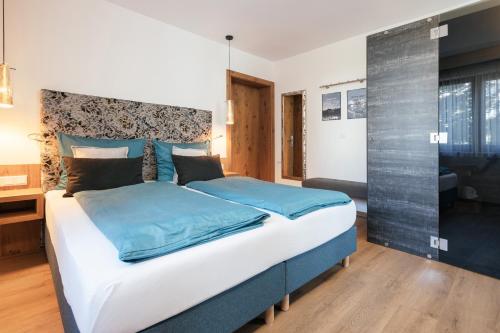 库夫施泰因Hotel VIKTORIAS HOME Kufstein的一间卧室配有一张带蓝色床单的大床
