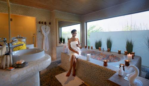Meghauli巴拉赫丛林小屋酒店的坐在浴室浴缸里的女人