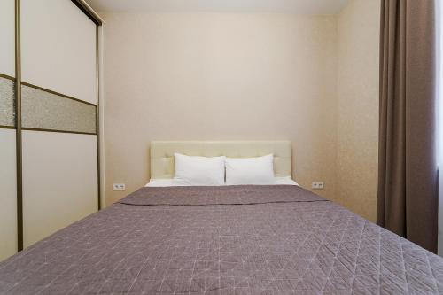 明斯克Apartments on Krasnaya Street的一间卧室配有一张大床和紫色毯子